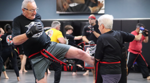 Adult Krav Maga students using kick defenses