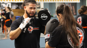 Adult Krav Maga students using focus mitts for striking practice