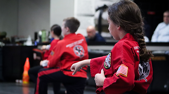 Kids martial arts student practicing a karate punching form